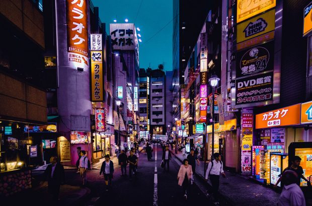 Tokyo street at night with neon signs and people walking